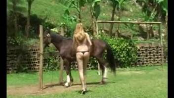 Horny blonde deepthroating a stallion's large cock