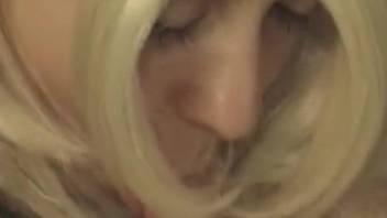 Wig-wearing hottie devouring a dog's juicy penis
